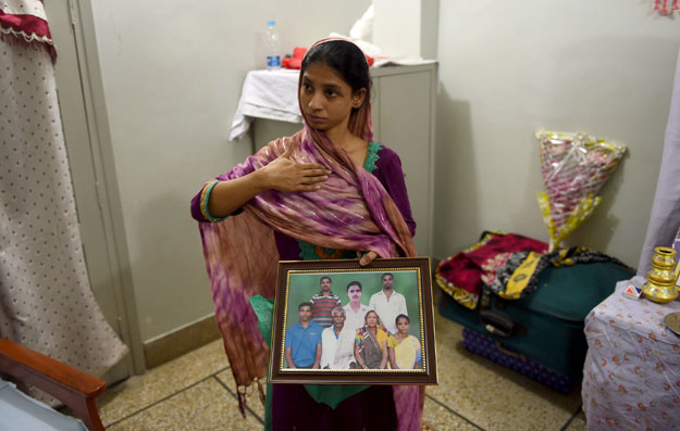 in this photograph taken on october 22 2015 deaf mute indian woman geeta holds a photograph of a family in india which she believes is her family during an afp interview at the edhi foundation in karachi photo afp