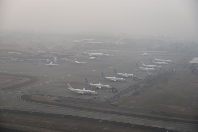 planes are seen parked on the tarmac of jakarta 039 s international airport in tangerang on october 25 2015 as haze looms over the capital city photo afp