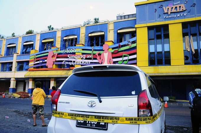 people look at the fire damaged popular three storey inul vizta karaoke club in the provincial capital of north sulawesi on october 25 2015 photo afp