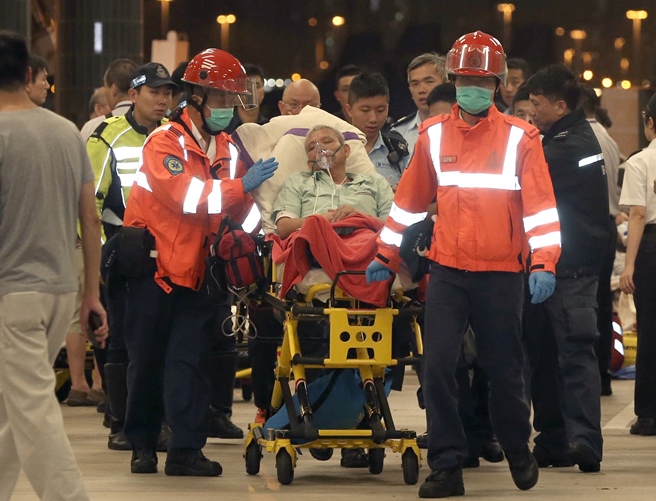 rescue personnel escort a victim injured in a ferry accident in hong kong on october 25 2015 photo afp