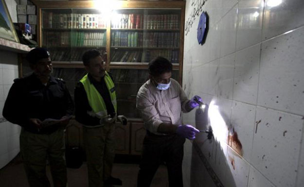 a police forensic expert gathers evidence from a bloodied wall at a murder crime scene in lahore pakistan october 1 2015 photo reuters