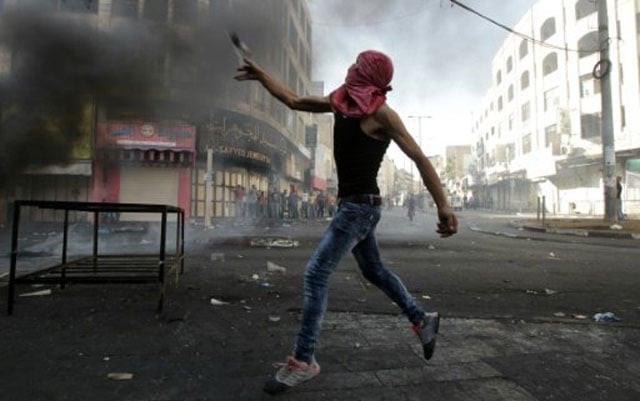a palestinian protester throws stones during clashes with israeli security forces in the occupied west bank on october 22 2015 photo afp file a palestinian protester throws stones during clashes with israeli security forces in the occupied west bank on october 22 2015 photo afp file