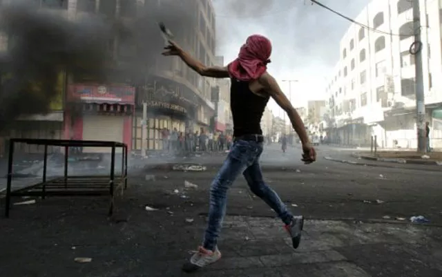 a palestinian protester throws stones during clashes with israeli security forces in the occupied west bank on october 22 2015 photo afp file a palestinian protester throws stones during clashes with israeli security forces in the occupied west bank on october 22 2015 photo afp file
