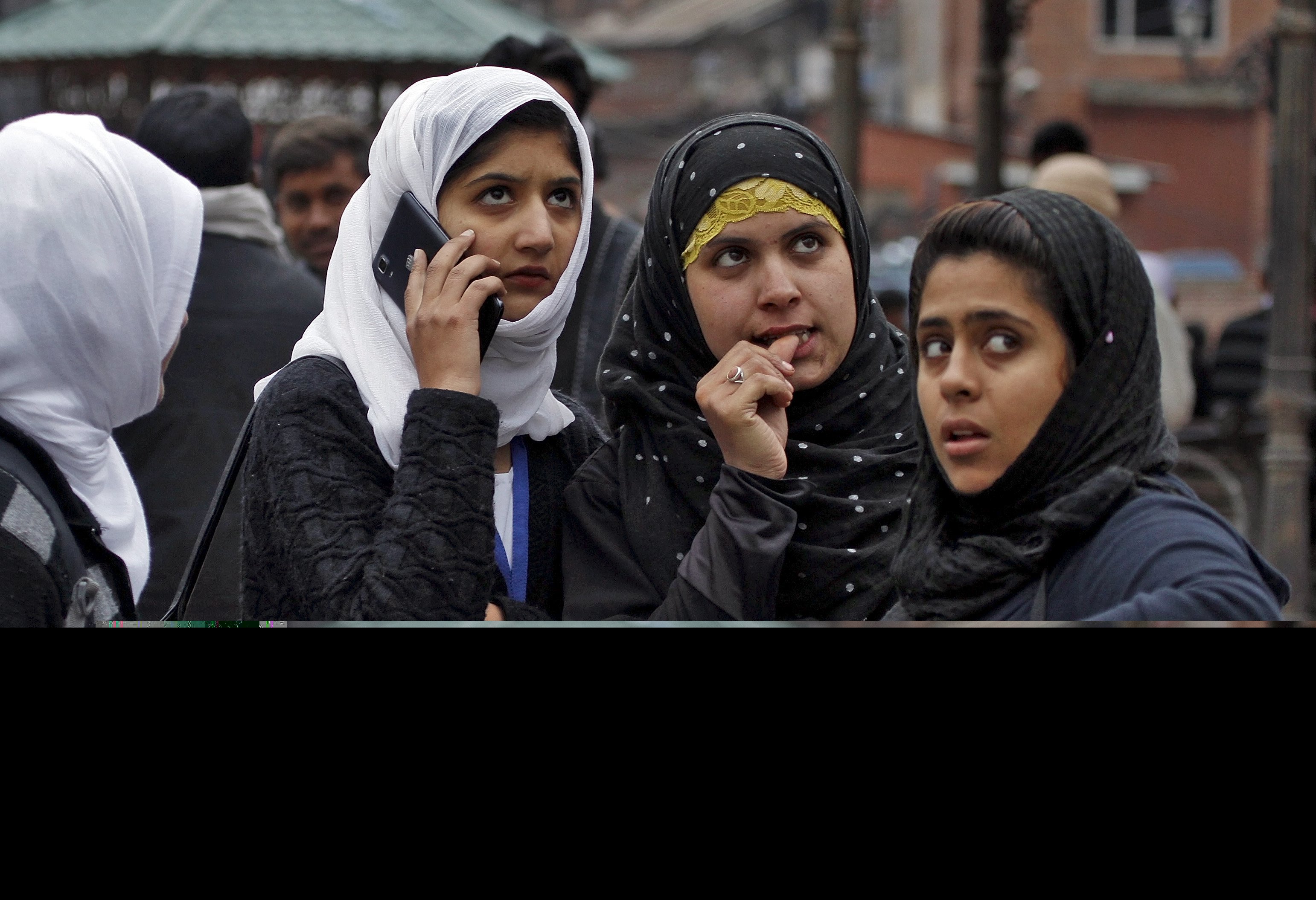 kashmiri girls stand on a road divider after vacating their office buildings following an earthquake in srinagar photo reuters