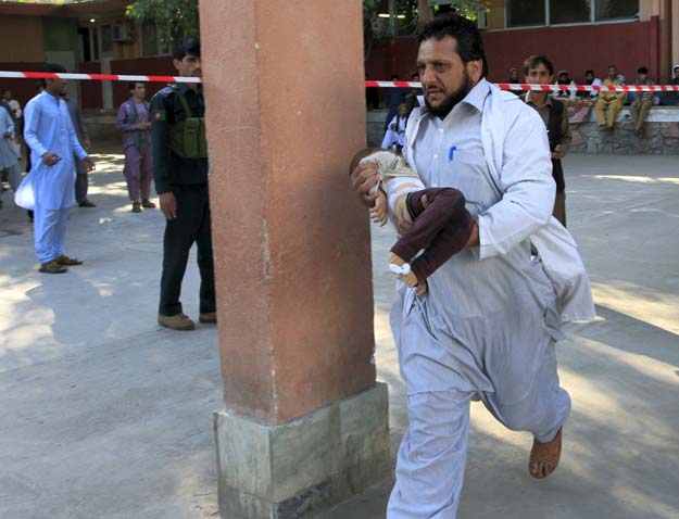 a rescue worker carries a child who was injured during an earthquake photo reuters