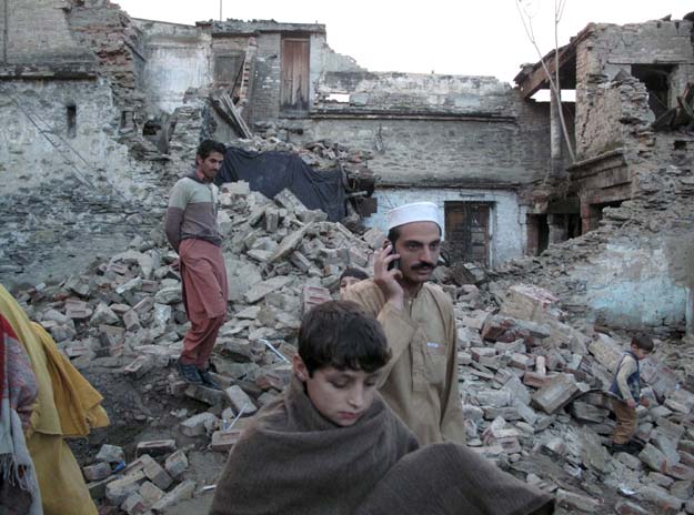 residents walk past the rubble of a house after it was damaged by an earthquake in mingora swat photo reuters