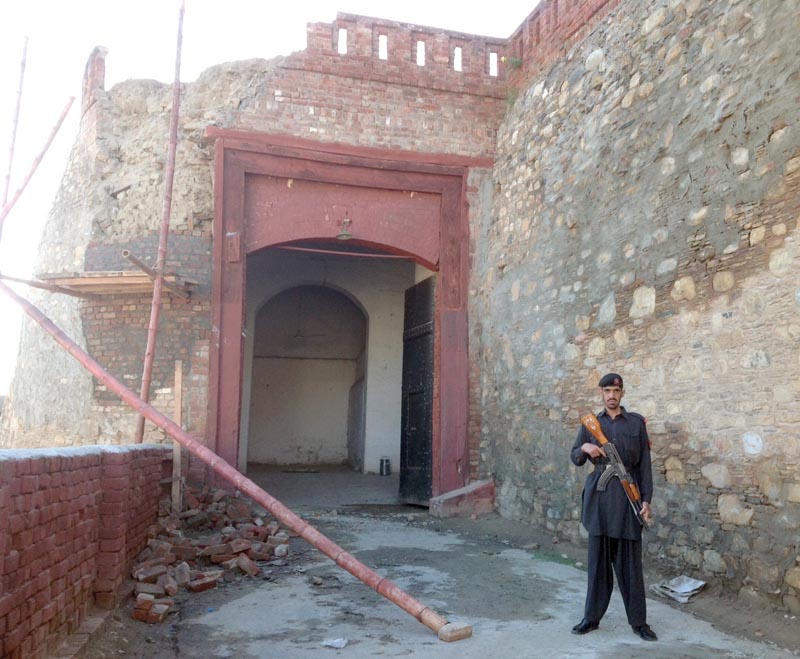 an fc soldier stands near the damaged shabqadar fort photos express