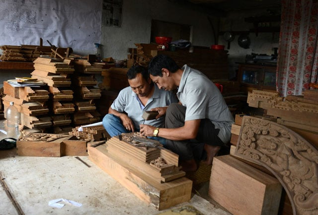 nepalese wood carver indra kaji shilpakar r teaches his son indra prasad shilpakar at his workshop in bhaktapur on the outskirts of kathmandu photo afp