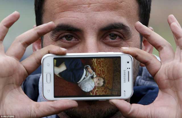 sirad from zabadani syria displays a picture of his son jad on his samsung phone as he waits and hopes to cross the border into austria photo reuters