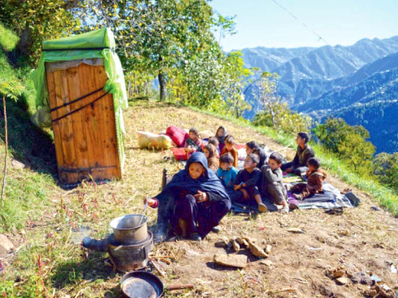 seventy year old gul subhana prepares food for her grandchildren in an open space in the quake hit shangla district photo afp