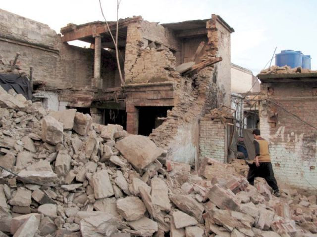 a man walks past the rubble of a house photo reuters a man walks past the rubble of a house photo reuters