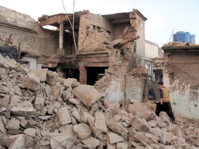 a man walks past the rubble of a house photo reuters