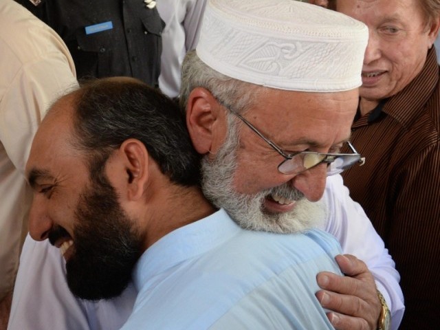 ajmal khan c in white cap vice chancellor of islamia college university peshawar hugs colleagues following a press conference in peshawar on august 29 2014 a day after his recovery from the taliban was secured photo afp
