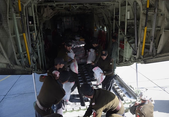 personnel unload relief food bags for earthquake survivors from a pakistan air force plane c 130 at an airport in chitral on october 30 2015 photo afp