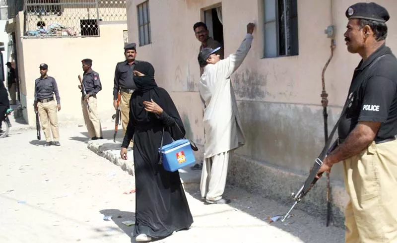 a lady health worker carries her polio vaccines while on duty in orangi town policemen stand guard to avert any untoward incident photo file a lady health worker carries her polio vaccines while on duty in orangi town policemen stand guard to avert any untoward incident photo file