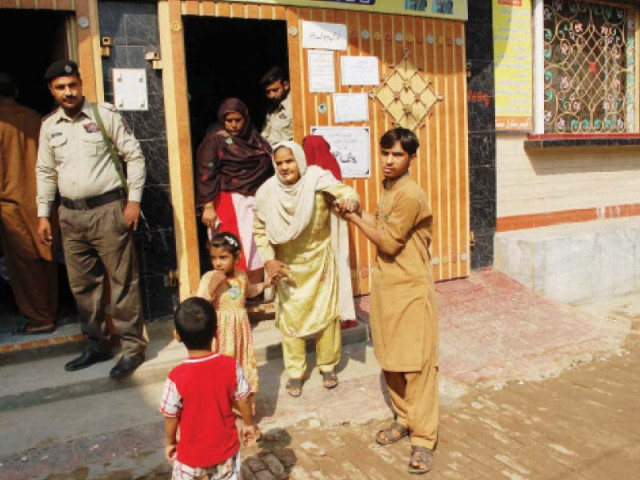 an elderly woman exits a polling station after casting her vote in faisalabad photos express online