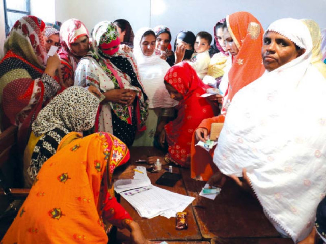 women voters gather around a polling agent at a polling station set up on barki road photo shafiq malik express women voters gather around a polling agent at a polling station set up on barki road photo shafiq malik express