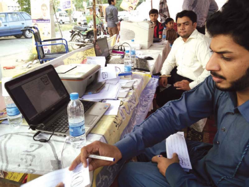 polling agents use automated voter lists to prepare slips for voters in uc 255 wapda town photo shafiq malik express