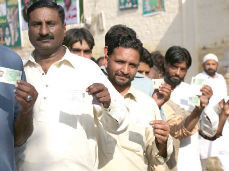 men show their identity cards to newsmen as they stand in a queue waiting to cast their votes photo shafiq malik express