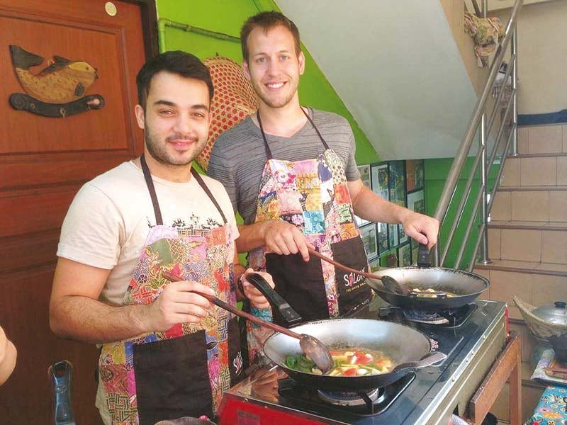 imtisal cooks with a fellow student at silom thai cooking school in bangkok thailand photos publicity