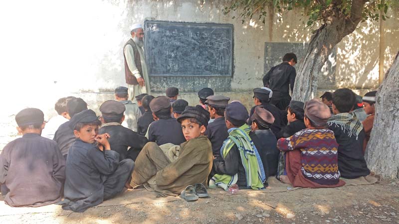 children study under the open sky while one of the classrooms is used as a kitchen and warehouse photos express