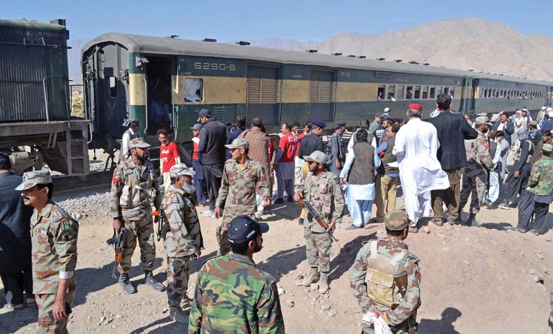 security officials stand next to a compartment of the train hit by an ied blast in mastung photo afp