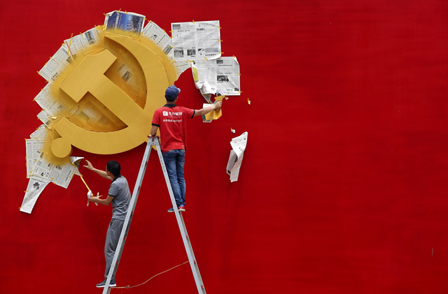workers peel papers off a wall as they re paint the chinese communist party flag at the nanhu revolution memorial museum in jiaxing photo reuters