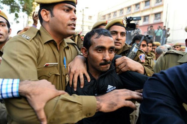 indian police escort uber taxi driver and accused rapist shiv kumar yadav centre following his court appearance in new delhi on december 8 2014 photo afp