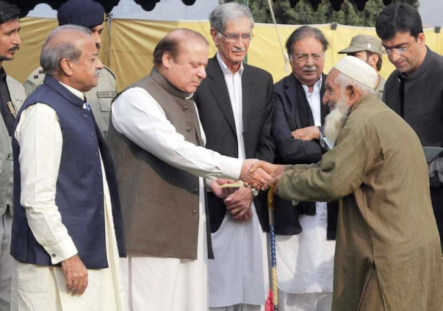 pm nawaz gives a cheque to an earthquake survivor in timergara photo afp pm nawaz gives a cheque to an earthquake survivor in timergara photo afp