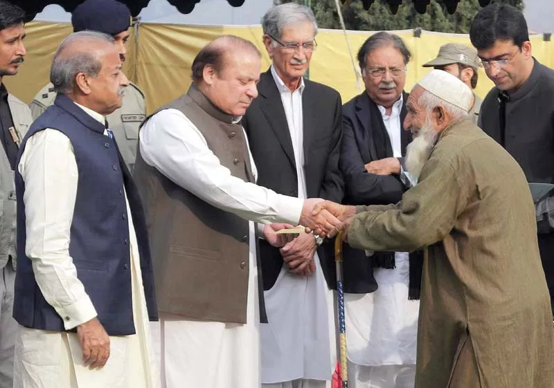 pm nawaz gives a cheque to an earthquake survivor in timergara photo afp pm nawaz gives a cheque to an earthquake survivor in timergara photo afp