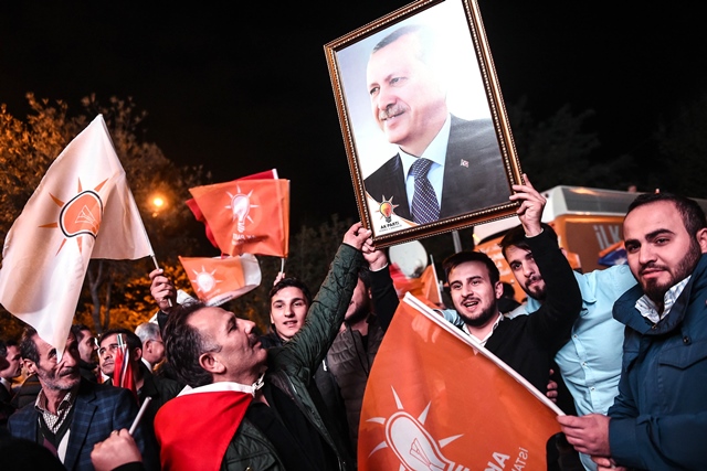 supporters of turkey 039 s justice and development party akp hold up a portrait of turkish president recep tayyip erdogan as they celebrate in istanbul after the first results in the country 039 s general election on november 1 2015 photo afp