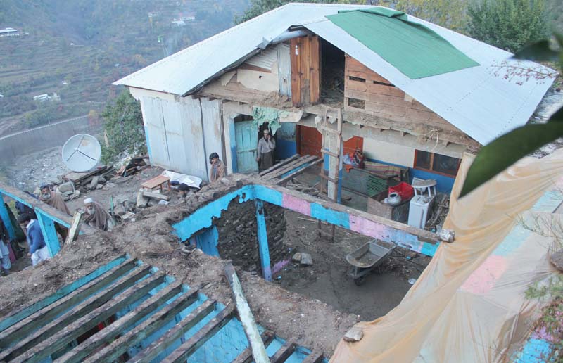 people stand inside a house destroyed by earthquake in shangla photo online