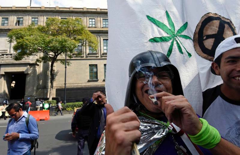 a demostrator smokes marijuana during a rally in front of the supreme court of justice in mexico city on november 4 2015 photo afp