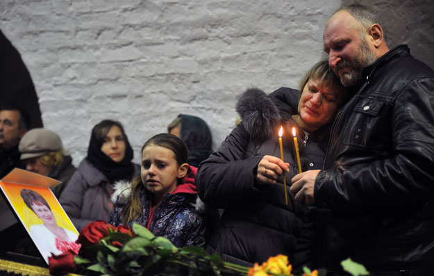 relatives grieve over the coffin of nina lushchenko 60 a victim of the russian metrojet airbus a321 crash during a funeral service at a church in velikiy novgorod on november 5 2015 ahead of her burial photo afp