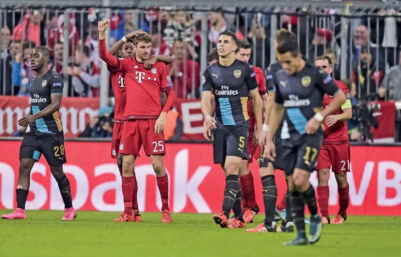 arsenal players look dejected after muller s strike completed the 5 1 rout and reduced their chances of progressing to the next round photo afp