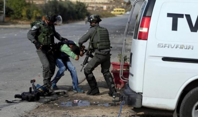 israeli border policemen beat a palestinian journalist during clashes with palestinian protesters near the jewish settlement of bet el near the west bank city of ramallah on october 30 2015 israeli border policemen beat a palestinian journalist during clashes with palestinian protesters near the jewish settlement of bet el near the west bank city of ramallah on october 30 2015