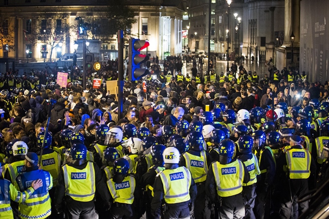 british police officers form a blockade around anti capitalist protesters during the quot million masks march quot organised by the group anonymous in trafalgar square in london on november 5 2015 photo afp