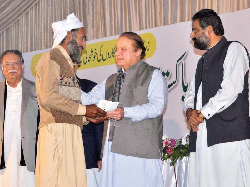 pm nawaz hands out a cheque to a farmer in sialkot photo app