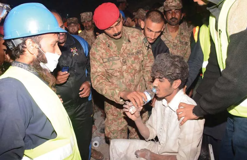 army officials and rescue workers give water to the survivor pulled out from under the debris photo ppi army officials and rescue workers give water to the survivor pulled out from under the debris photo ppi