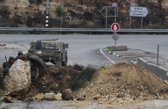 israeli soldiers stand guard at the main northern entrance of the west bank city of hebron on november 7 2015 photo afp