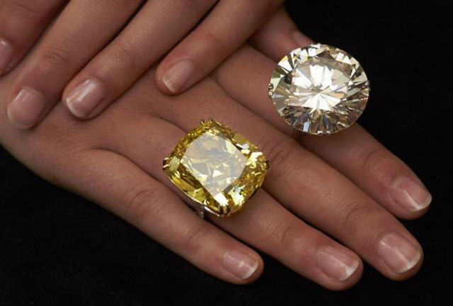 a model poses with a vivid yellow 100 09 carats diamond l and a 103 46 carats diamond ring during an auction preview at sotheby 039 s in geneva may 7 2014 photo reuters