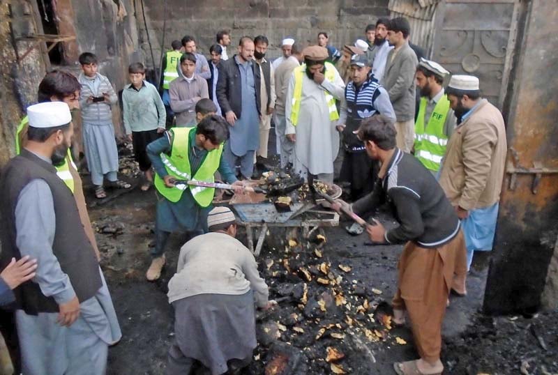 workers remove debris from burnt godown of bakery at khal bazaar photo inp