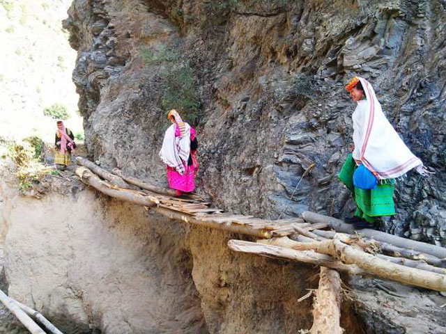 kalash women in hindu kush mountains walk along a makeshift bridge after paths were swept away by torrential rainfall photo reuters