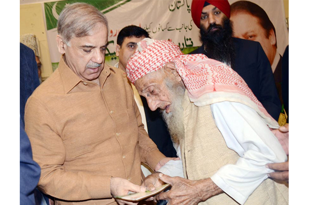 chief minister shahbaz sharif distributing financial assistance cheque among the farmers photo inp