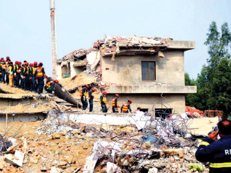 rescue workers at the site of the collapsed factory photo express