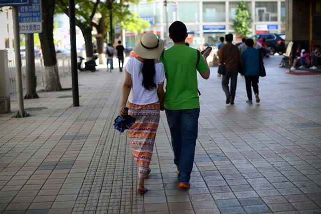 a couple holds hands as they walk on the streets of beijing photo afp a couple holds hands as they walk on the streets of beijing photo afp