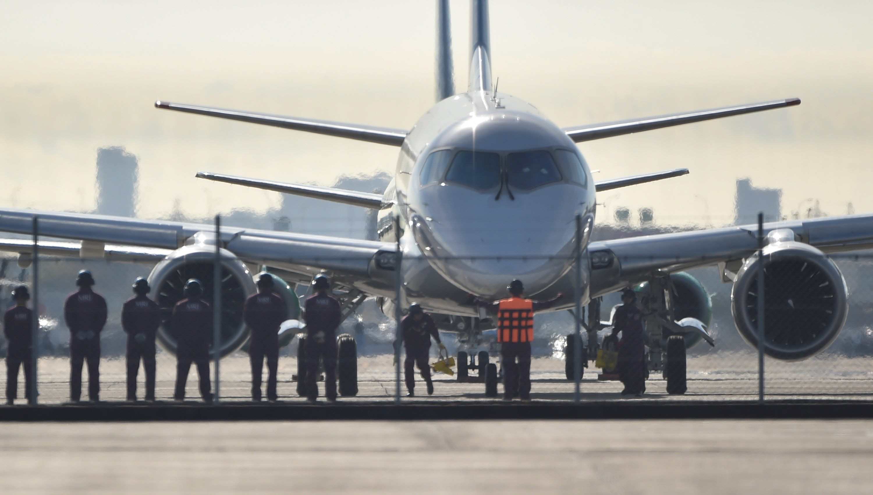 ground staff prepare to see off japan 039 s first domestically produced passenger jet the mitsubishi regional jet mrj prior to its maiden test flight at nagoya airport aichi prefecture on november 11 2015 japan 039 s first domestic passenger jet successfully took off on its maiden test flight november 11 culminating a decade of development for a programme aimed at competing with brazilian and canadian rivals in the global market for smaller aircraft photo afp