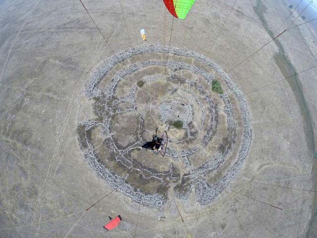 a general aerial view shows a prehistoric stone monument known as rujm el hiri in arabic meaning quot stone heap of the wild cat quot as a paraglider surfs above it in this july 24 2014 picture photo reuters