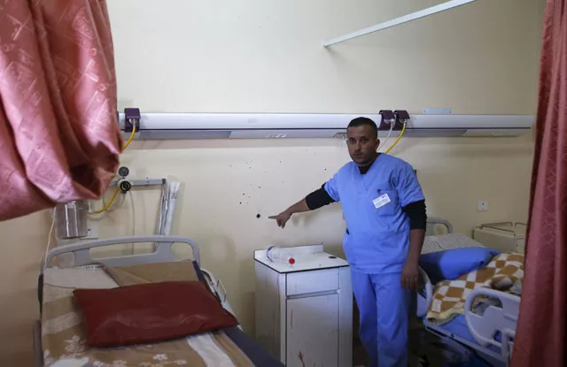 a medic shows to journalists a bullet hole in a wall surrounded by blood stains of a palestinian man who was killed by israeli undercover forces during a raid at al ahly hospital in the west bank city of hebron november 12 2015 photo reuters a medic shows to journalists a bullet hole in a wall surrounded by blood stains of a palestinian man who was killed by israeli undercover forces during a raid at al ahly hospital in the west bank city of hebron november 12 2015 photo reuters