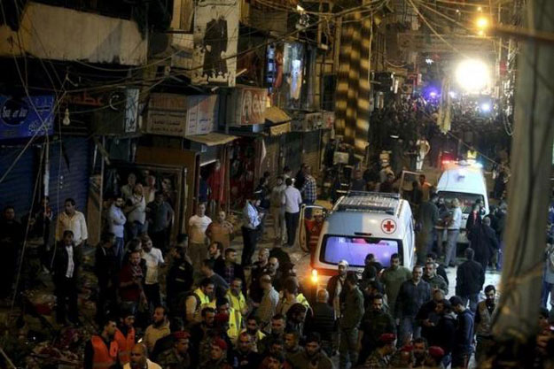 red cross vehicles drive by as residents and lebanese army members inspect a damaged area caused by two explosions in beirut 039 s southern suburbs lebanon november 12 2015 photo reuters